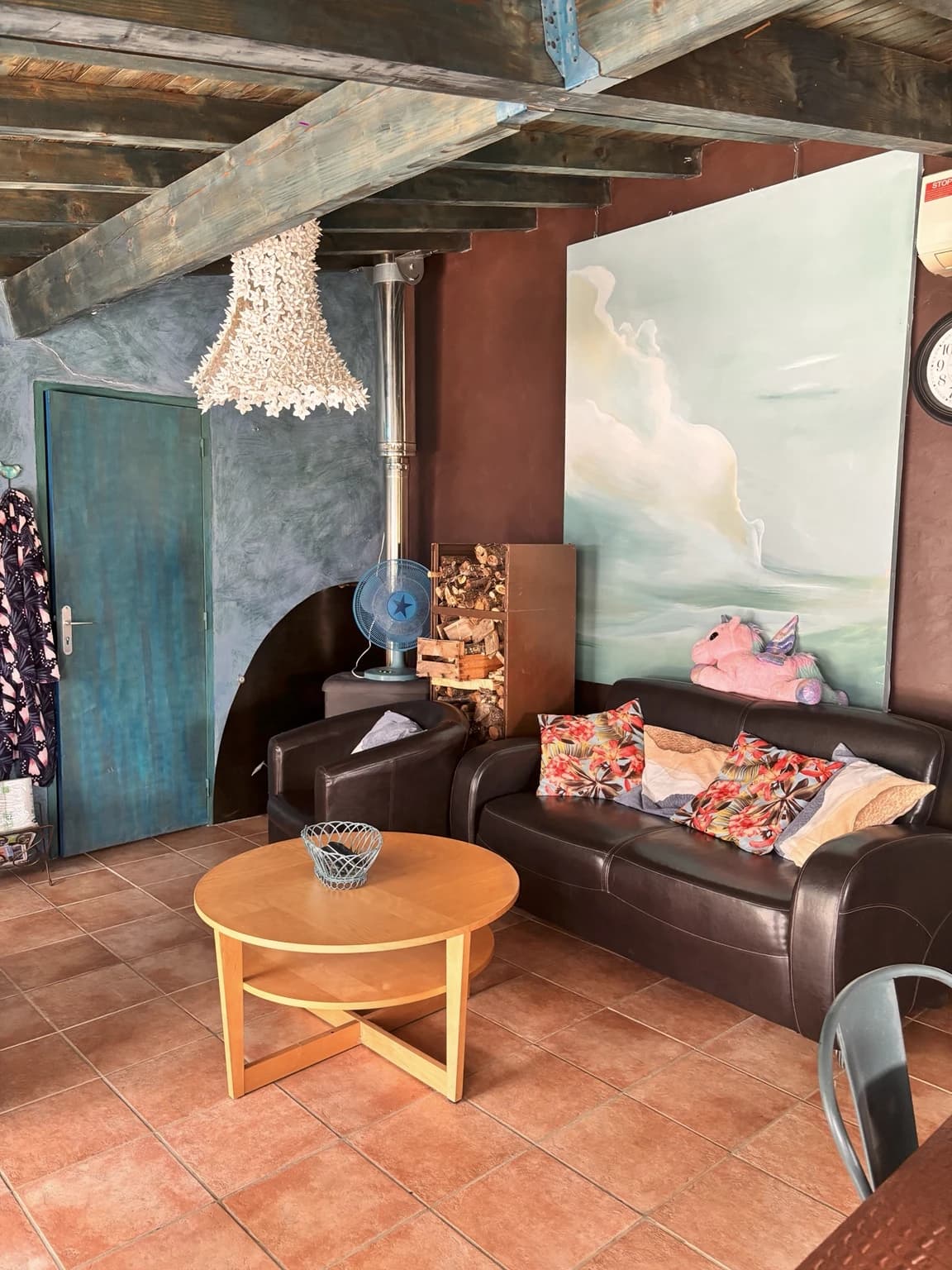 Le salon cosy, son poêle à bois et sa fresque de nuages